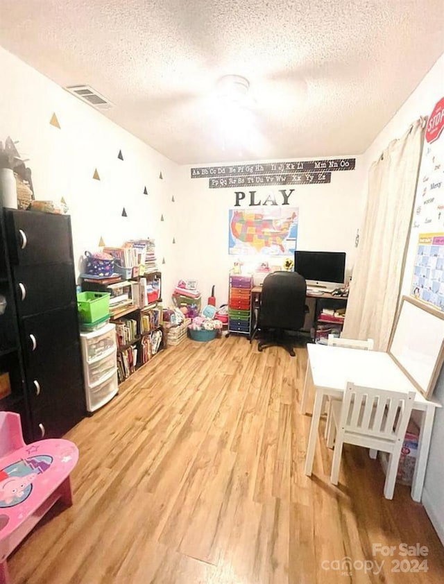 rec room featuring hardwood / wood-style floors and a textured ceiling