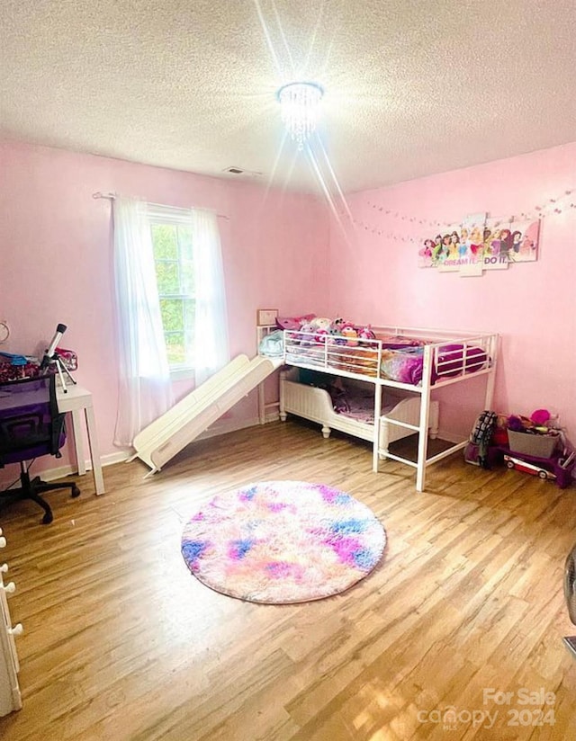 bedroom featuring a textured ceiling and hardwood / wood-style flooring