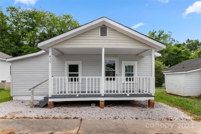 rear view of house featuring a storage shed and a porch