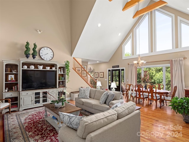 living room featuring beam ceiling, a notable chandelier, light hardwood / wood-style flooring, and high vaulted ceiling