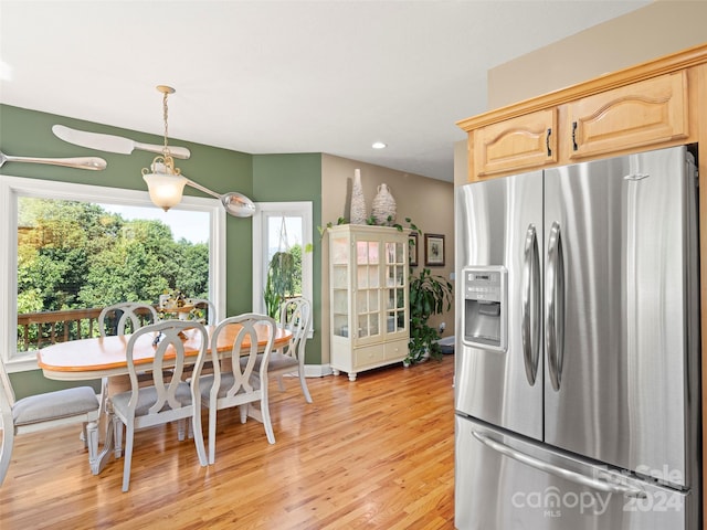 kitchen with light hardwood / wood-style floors, decorative light fixtures, light brown cabinetry, and stainless steel refrigerator with ice dispenser