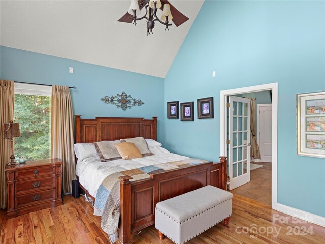 bedroom with hardwood / wood-style flooring and high vaulted ceiling