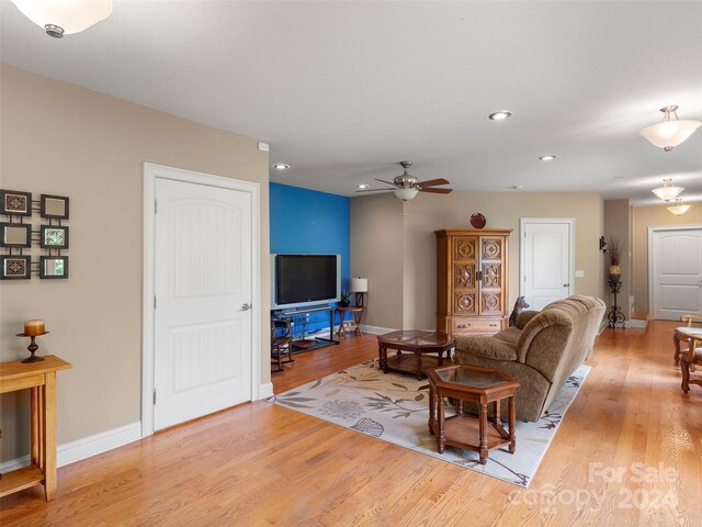 living room featuring light hardwood / wood-style flooring and ceiling fan