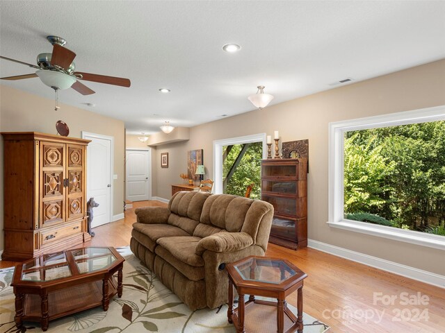 living room with light wood-type flooring and ceiling fan