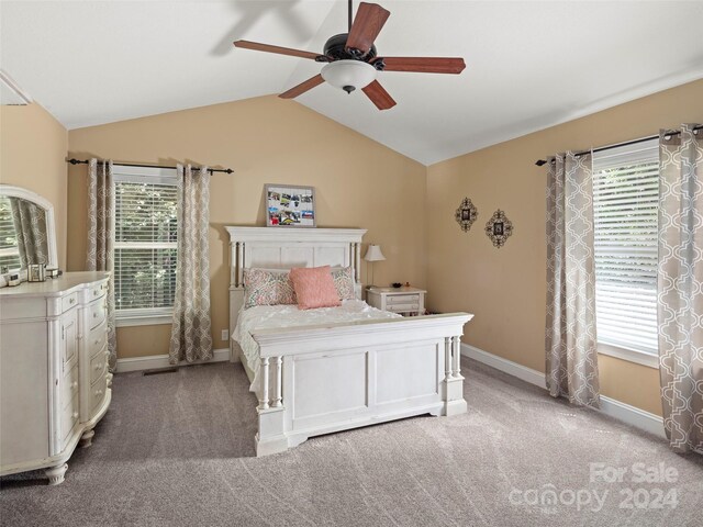 unfurnished bedroom featuring multiple windows, vaulted ceiling, and carpet floors