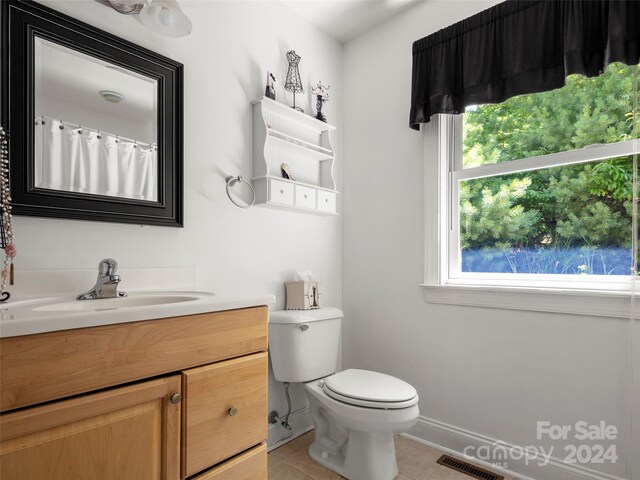 bathroom with vanity, tile patterned floors, toilet, and a healthy amount of sunlight