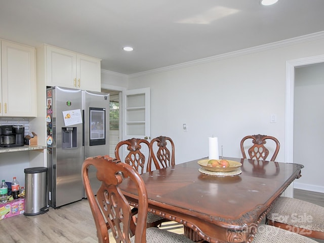 dining room featuring ornamental molding and light wood-type flooring