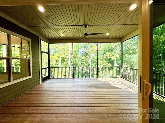 unfurnished sunroom with ceiling fan