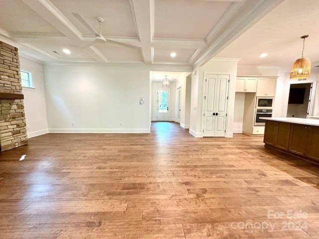 unfurnished living room with ceiling fan, ornamental molding, beam ceiling, coffered ceiling, and light hardwood / wood-style floors