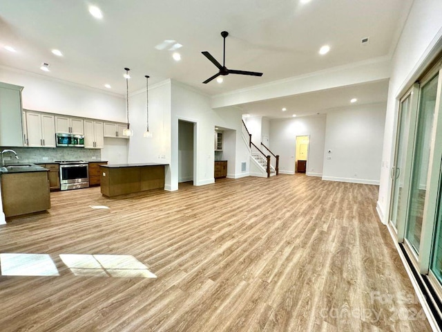 kitchen featuring light hardwood / wood-style floors, a kitchen island, ceiling fan, and stainless steel appliances