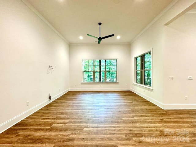 empty room featuring light wood-type flooring, crown molding, ceiling fan, and a wealth of natural light