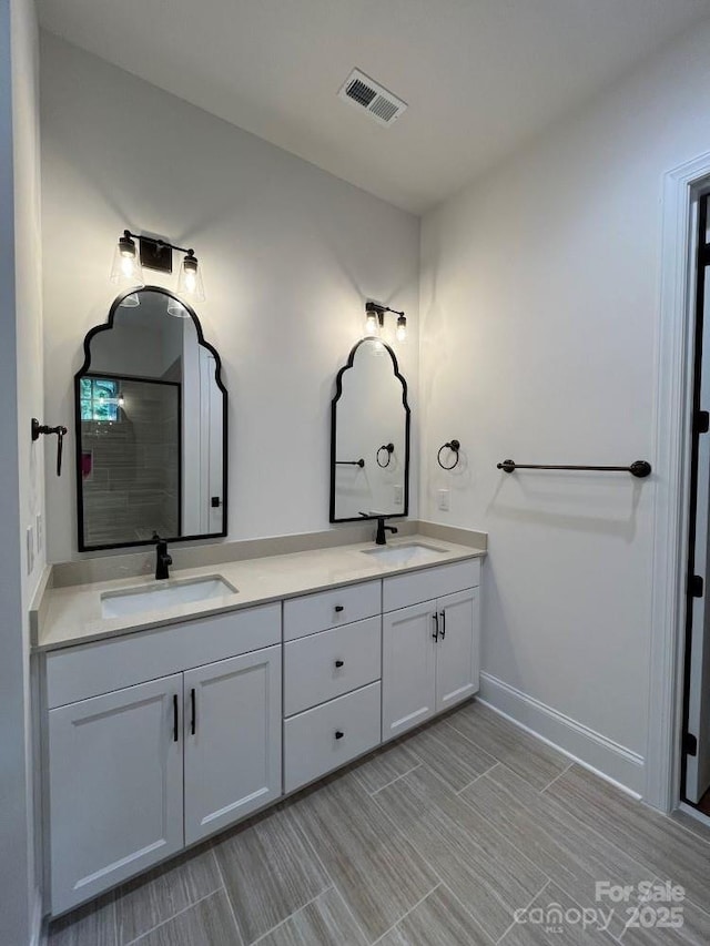 bathroom with visible vents, a sink, and double vanity