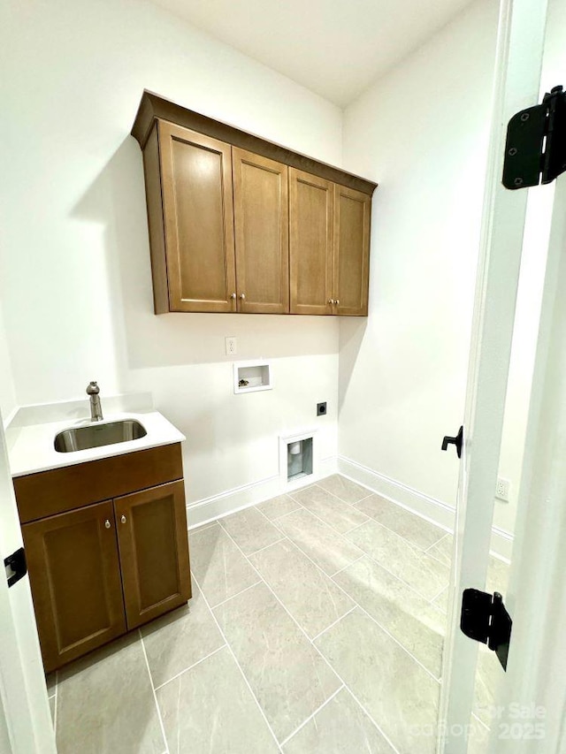 clothes washing area with hookup for a washing machine, cabinet space, hookup for an electric dryer, a sink, and baseboards