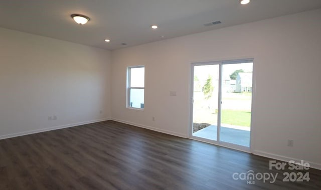 unfurnished room with dark hardwood / wood-style flooring and a healthy amount of sunlight