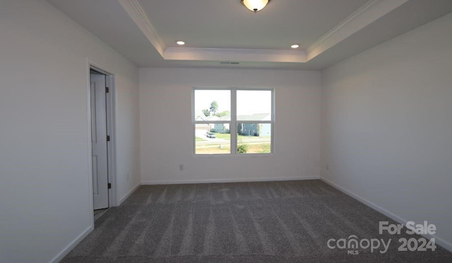 carpeted empty room featuring a tray ceiling and crown molding