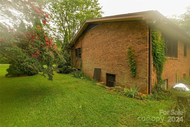 view of side of home with a yard