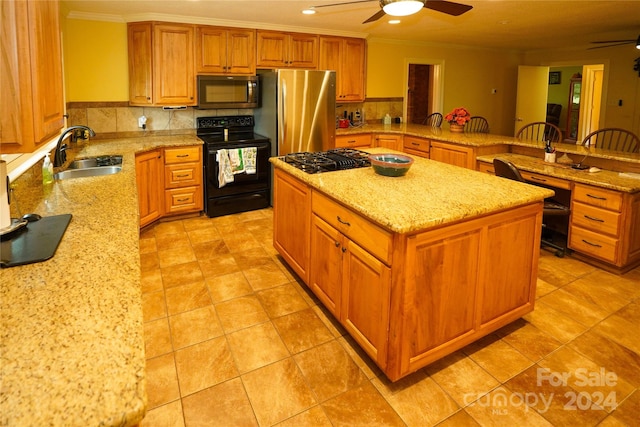 kitchen with a kitchen island, sink, ceiling fan, and stainless steel appliances