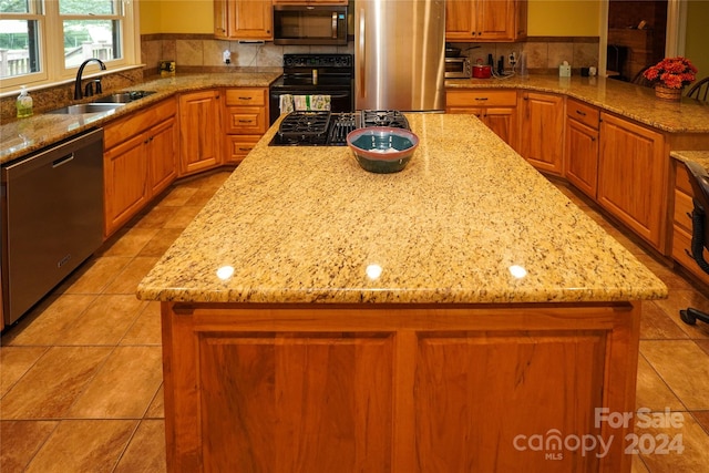 kitchen with sink, a center island, decorative backsplash, and stainless steel appliances