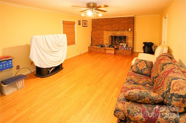 living room with crown molding, a fireplace, ceiling fan, and hardwood / wood-style flooring