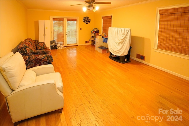 living room with hardwood / wood-style flooring, crown molding, and ceiling fan