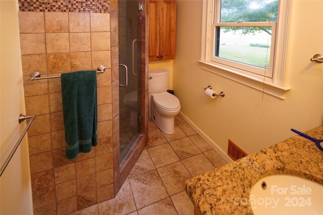 bathroom featuring toilet, tile patterned flooring, and walk in shower