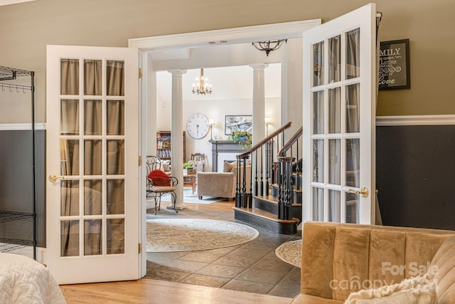 foyer featuring ornate columns and a notable chandelier