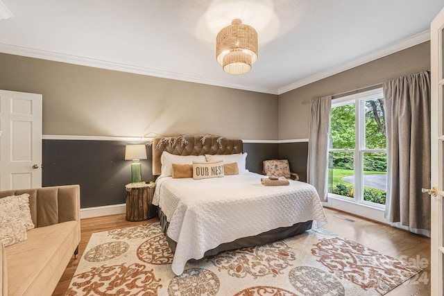 bedroom with light wood-type flooring and ornamental molding