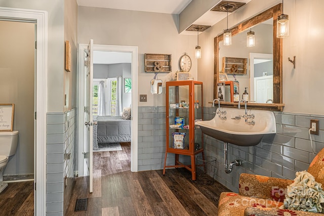 bathroom with toilet, hardwood / wood-style flooring, and sink