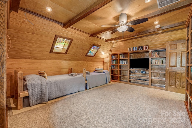 carpeted bedroom with ceiling fan, vaulted ceiling with skylight, wood ceiling, and wooden walls