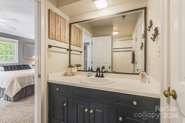 bathroom featuring walk in shower, vanity, and crown molding