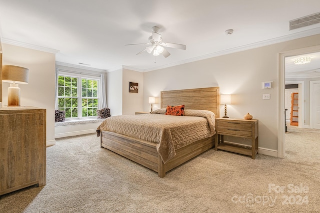 carpeted bedroom with ceiling fan and ornamental molding