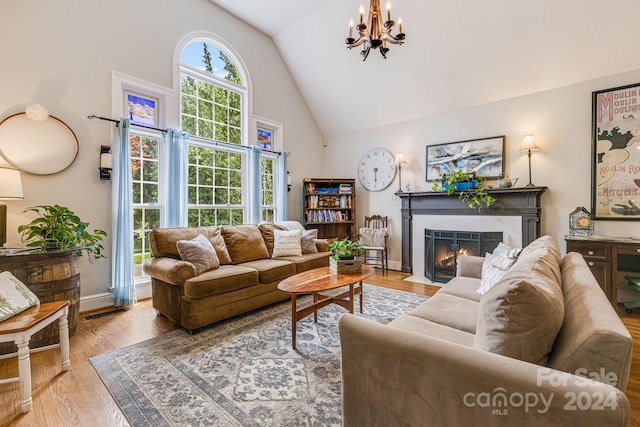 living room with a healthy amount of sunlight, an inviting chandelier, and hardwood / wood-style floors