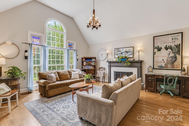 living room with light hardwood / wood-style flooring, lofted ceiling, and a chandelier