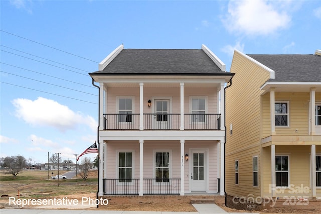 view of front facade featuring a balcony, a porch, and a shingled roof