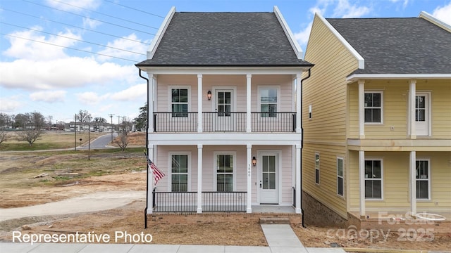 view of front of house with a balcony, covered porch, and a shingled roof