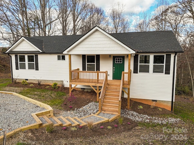 view of front of property with crawl space, stairway, a porch, and roof with shingles