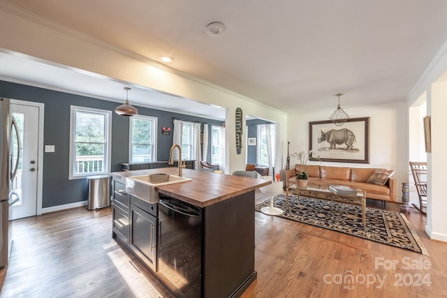 kitchen with hardwood / wood-style floors, black dishwasher, hanging light fixtures, a kitchen island with sink, and sink