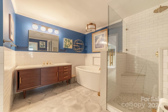 bathroom featuring separate shower and tub, tile patterned floors, tile walls, vanity, and ornamental molding