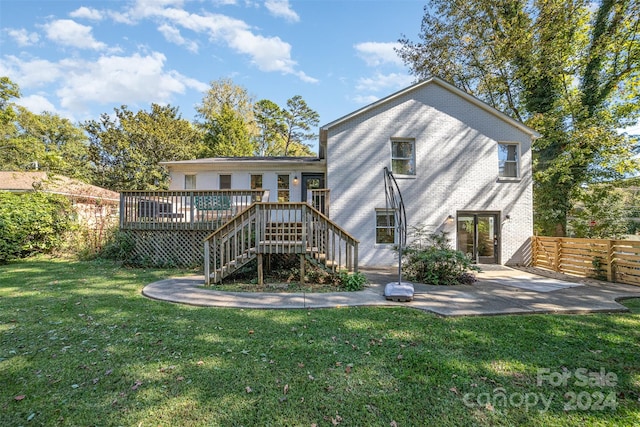 back of house with a wooden deck, a yard, and a patio