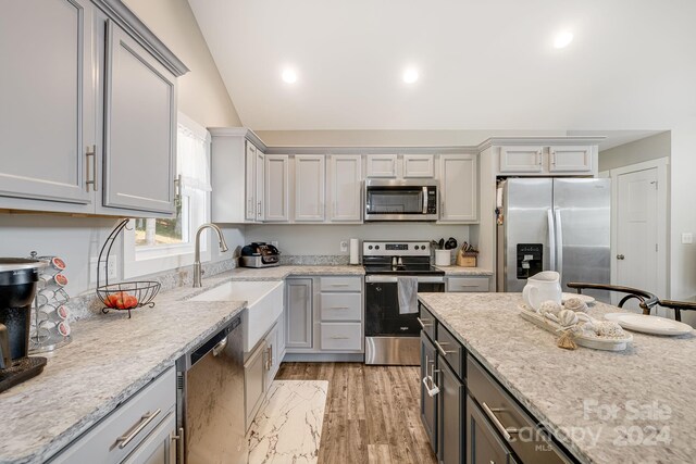 kitchen featuring appliances with stainless steel finishes, a sink, and gray cabinetry