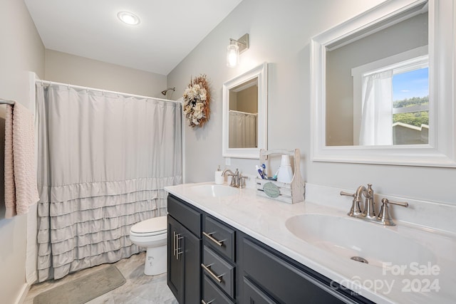 full bath featuring double vanity, a shower with curtain, toilet, and a sink