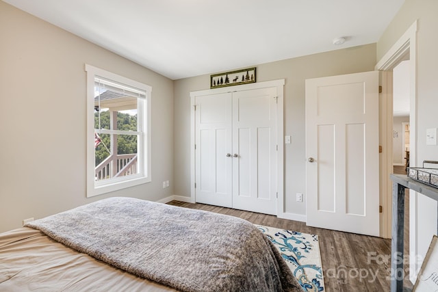 bedroom featuring a closet, baseboards, and wood finished floors