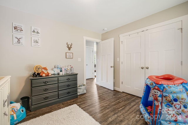 bedroom featuring dark wood-style floors, baseboards, and a closet