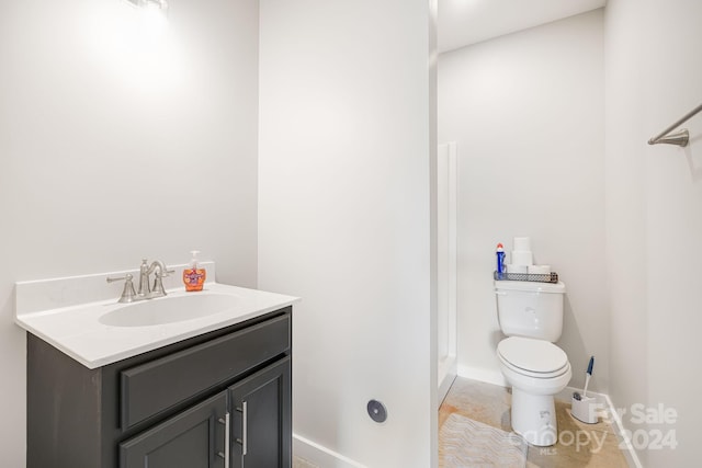 bathroom featuring toilet, tile patterned flooring, vanity, and baseboards