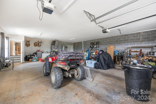 garage featuring concrete block wall and a garage door opener