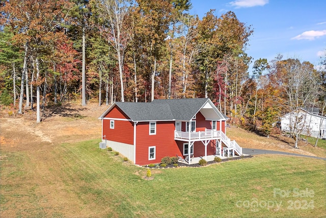 exterior space with a front lawn, stairway, and a wooden deck