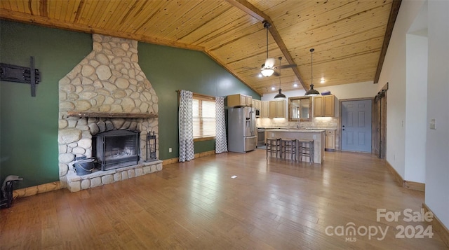 kitchen featuring stainless steel fridge with ice dispenser, a center island, wood ceiling, and decorative light fixtures