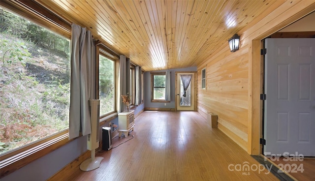 interior space featuring lofted ceiling, wooden ceiling, and a wall unit AC