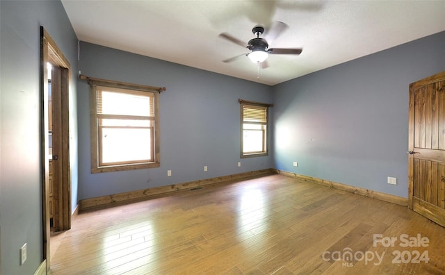 spare room with ceiling fan and light wood-type flooring