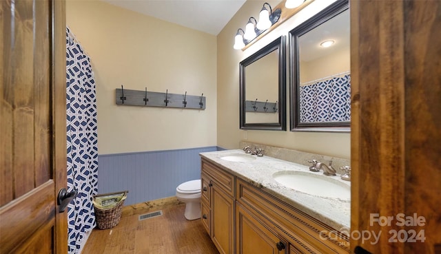 bathroom with toilet, vanity, and hardwood / wood-style flooring